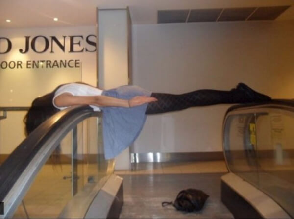 A woman planking on an escalator